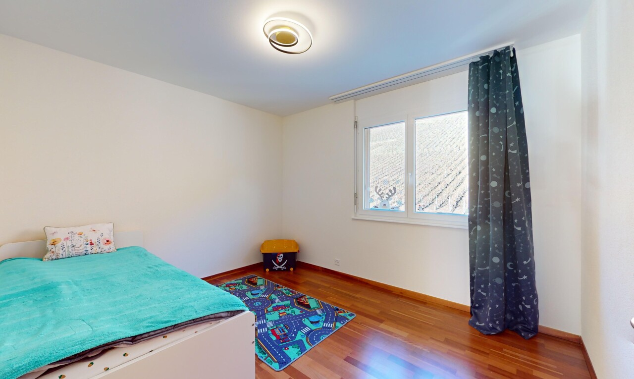chambre avec lumière naturelle et plancher de bois