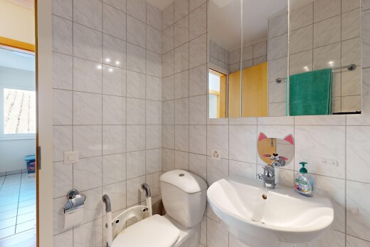 salle de bains avec vasque, lumière naturelle, miroir, et mur carrelé