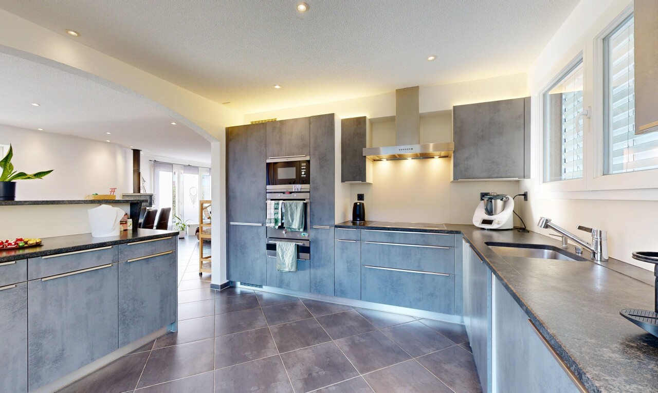 cuisine avec dark floor, hotte, dark countertops, lumière naturelle, et natural light
