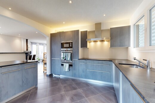 cuisine avec dark floor, hotte, dark countertops, lumière naturelle, et natural light