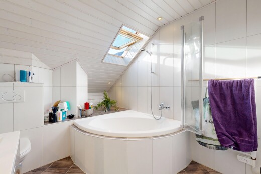 bathroom with a skylight, recessed lighting, and vaulted ceiling