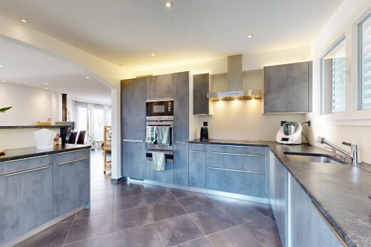 cuisine avec dark floor, hotte, dark countertops, lumière naturelle, et natural light