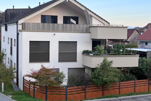 façade avec balcon, bardage en stuc, clôture, et toit en métal