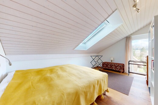 room with a skylight, a vaulted wood ceiling, and wood finished floors