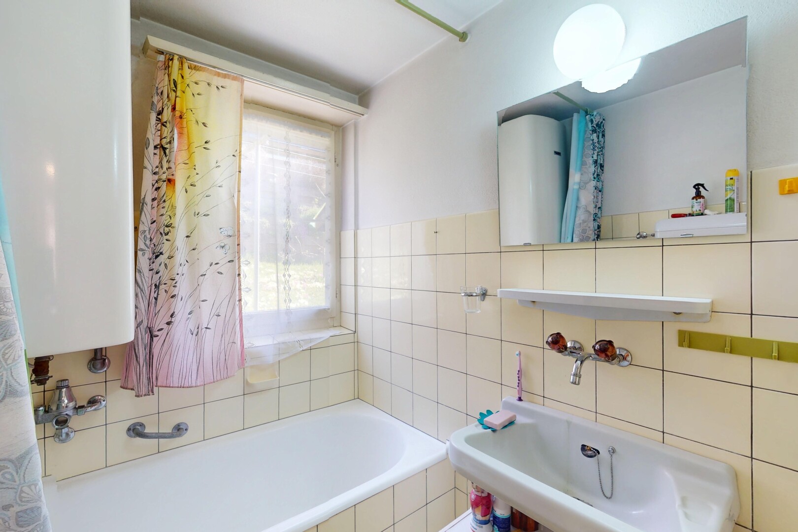 bad mit komplettes badezimmer, spiegel, natürliches licht, fliesenwand, und wasserkocher