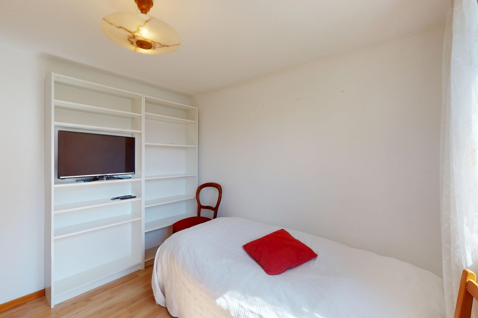 zimmer / schlafzimmer mit holzfußboden, fernseher, und gipskartonwand