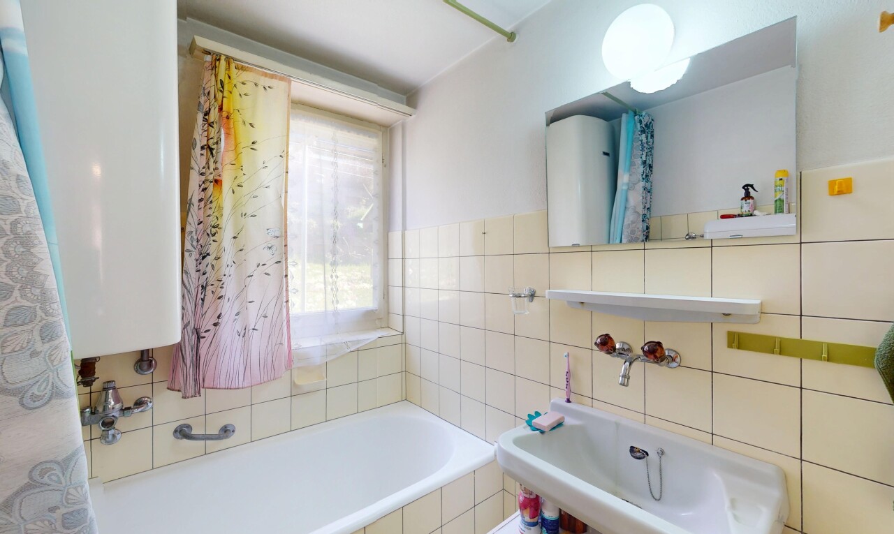 bad mit komplettes badezimmer, spiegel, natürliches licht, fliesenwand, und wasserkocher
