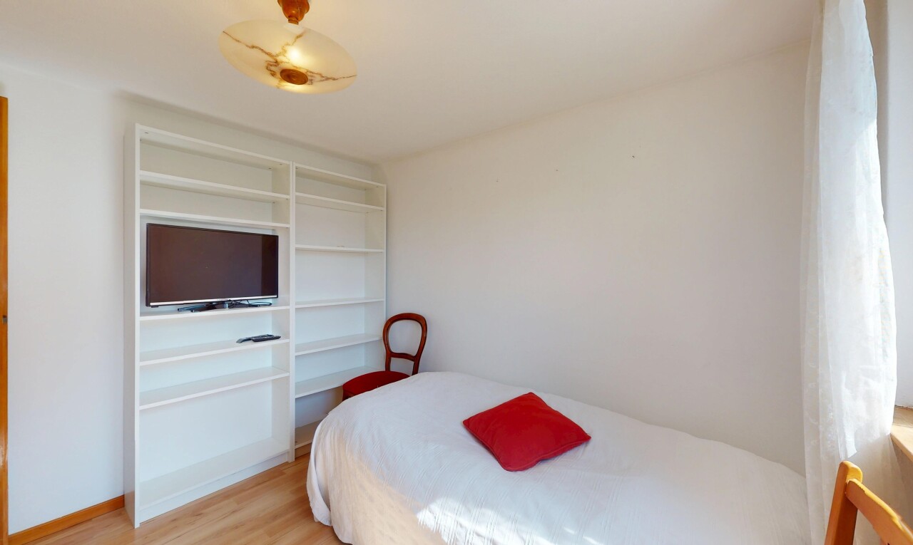 zimmer / schlafzimmer mit holzfußboden, fernseher, und gipskartonwand