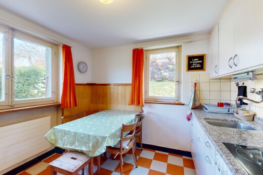 kitchen with a sink, white cabinetry, black electric stovetop, a wainscoted wall, and light floors