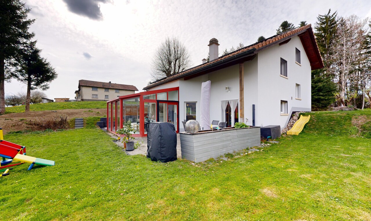 außenansicht mit wintergarten, property visible, stuckverkleidung, rasen, und schornstein