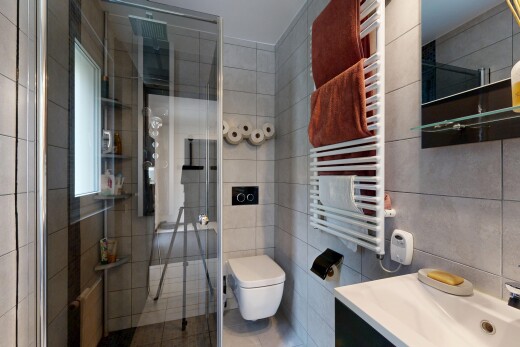 salle de bains avec radiateur, miroir, chauffe-serviettes, douche, et salle de bain complète