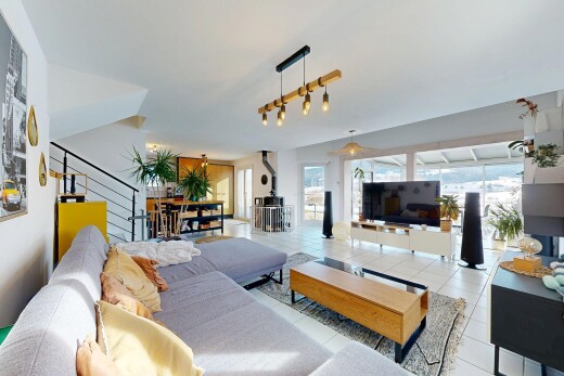 living area with tile patterned floors, a wood stove, and stairs