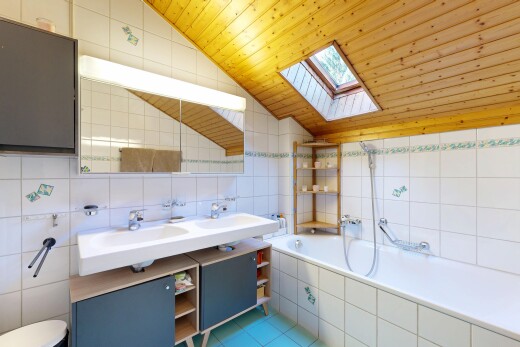 bathroom with tile walls, wooden ceiling, vaulted ceiling, a bath, and a skylight