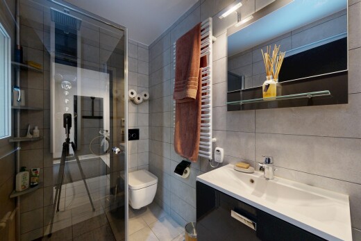 bathroom featuring a towel warmer, vanity, a stall shower, tile walls, and tile patterned flooring