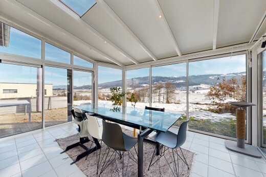 dining area with expansive windows, plenty of natural light, lofted ceiling, light tile patterned floors, and a mountain view