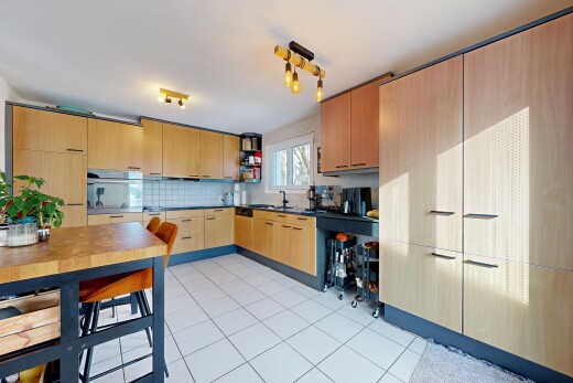 kitchen featuring dark countertops, open shelves, decorative backsplash, light brown cabinets, and light tile patterned flooring