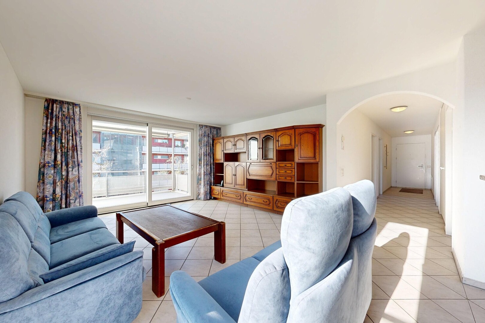 living room featuring arched walkways and light tile patterned floors