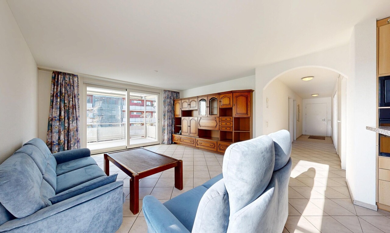 living room featuring arched walkways and light tile patterned floors