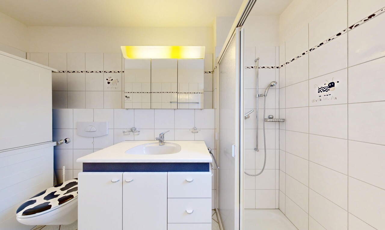 full bathroom featuring a stall shower, vanity, backsplash, and tile walls