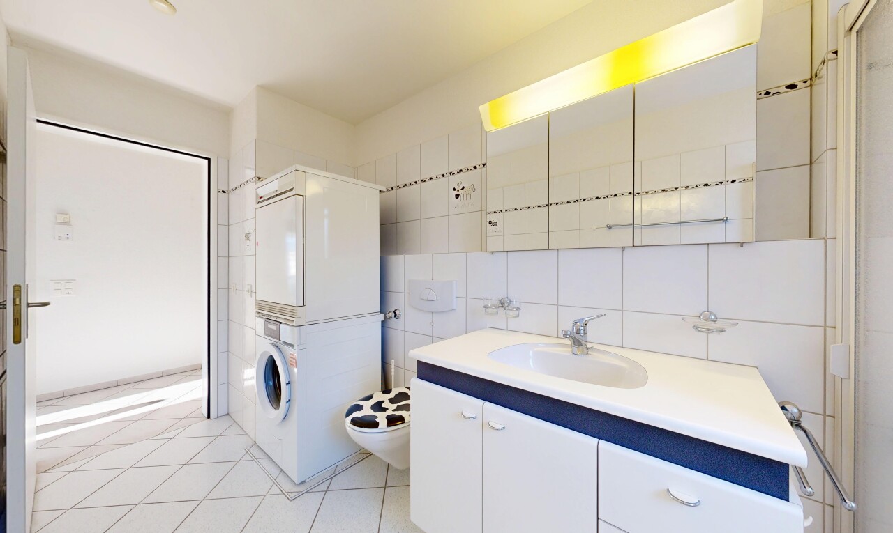 bathroom with vanity, light tile patterned flooring, tile walls, tasteful backsplash, and stacked washer and clothes dryer