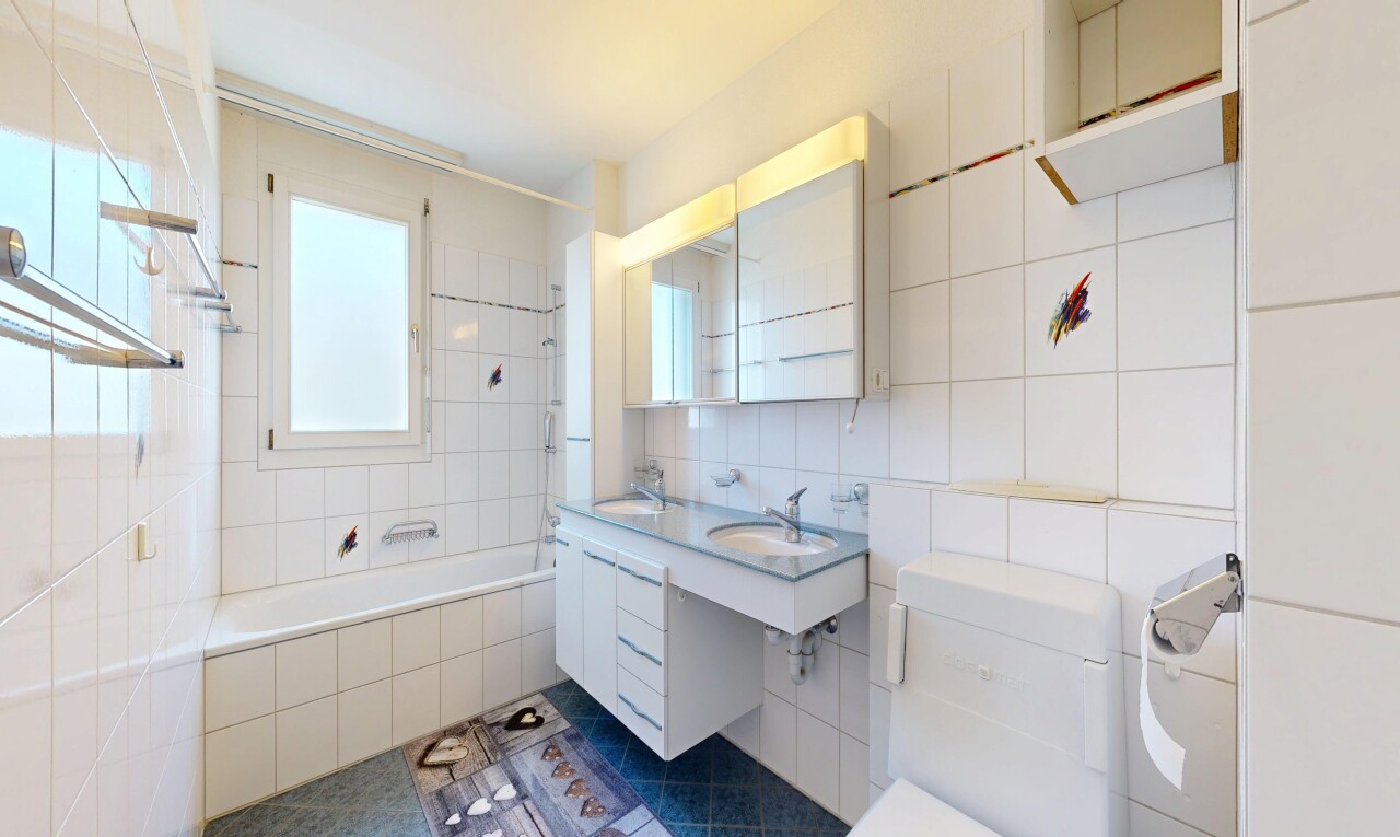 bathroom featuring tiled shower / bath combo, tile walls, vanity, and decorative backsplash