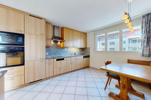 cuisine avec light brown cabinets, armoires marron clair, four, pendant lighting, et éclairage suspendu
