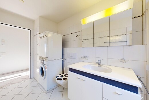 bathroom with vanity, light tile patterned flooring, tile walls, tasteful backsplash, and stacked washer and clothes dryer