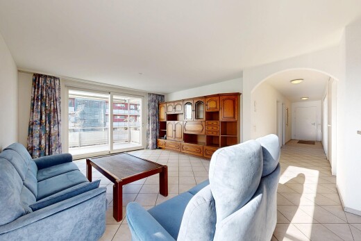 living room featuring arched walkways and light tile patterned floors
