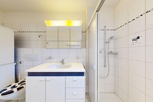 full bathroom featuring a stall shower, vanity, backsplash, and tile walls