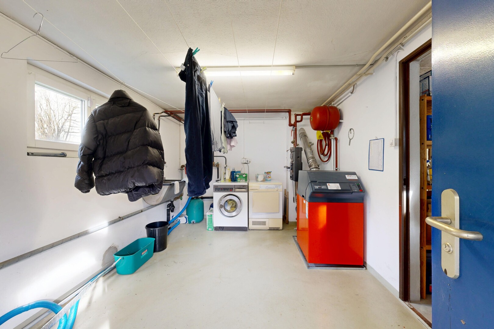 buanderie avec buanderie, concrete floor, sol en béton, drywall, et cloison sèche