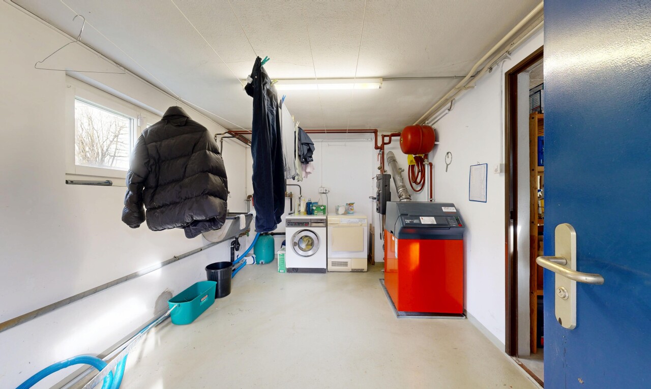 buanderie avec buanderie, concrete floor, sol en béton, drywall, et cloison sèche