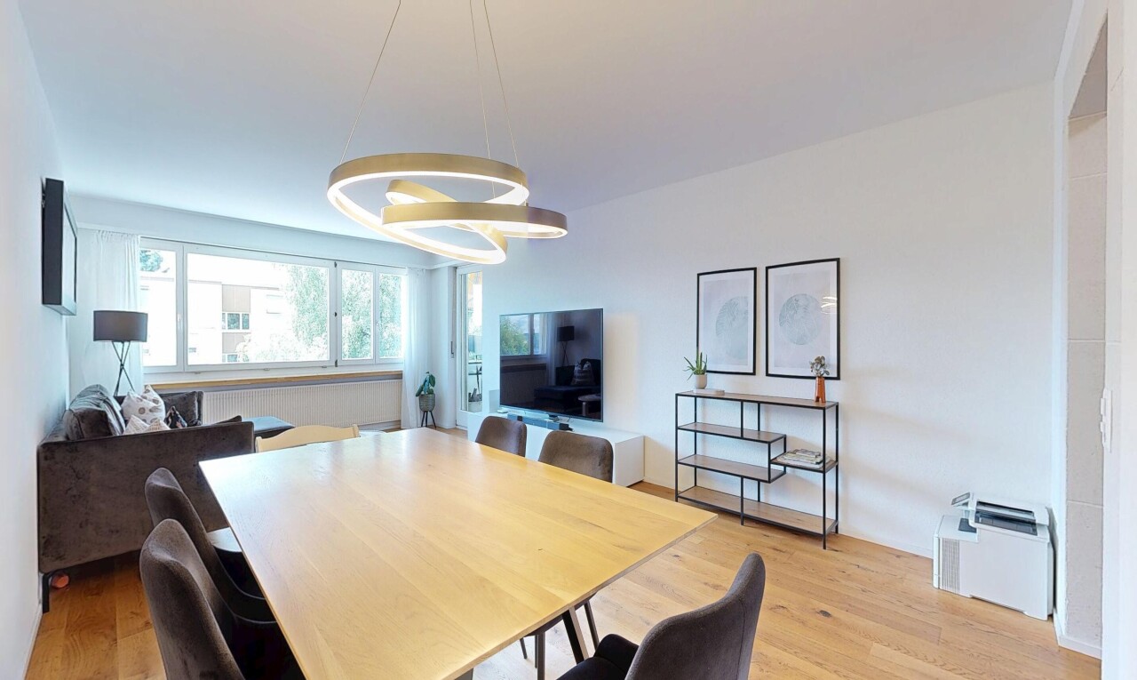 wohn- / esszimmer mit fernseher, gipskartonwand, drywall, holzfußboden, und wood finish floor