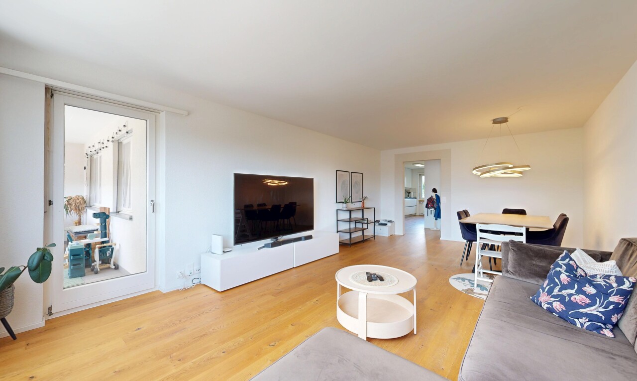 wohn- / esszimmer mit fernseher, holzfußboden, wood finish floor, gipskartonwand, und drywall