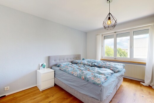 zimmer / schlafzimmer mit wood finish floor, holzfußboden, pendelleuchte, drywall, und gipskartonwand