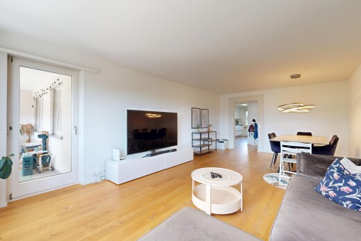 wohn- / esszimmer mit fernseher, holzfußboden, wood finish floor, gipskartonwand, und drywall