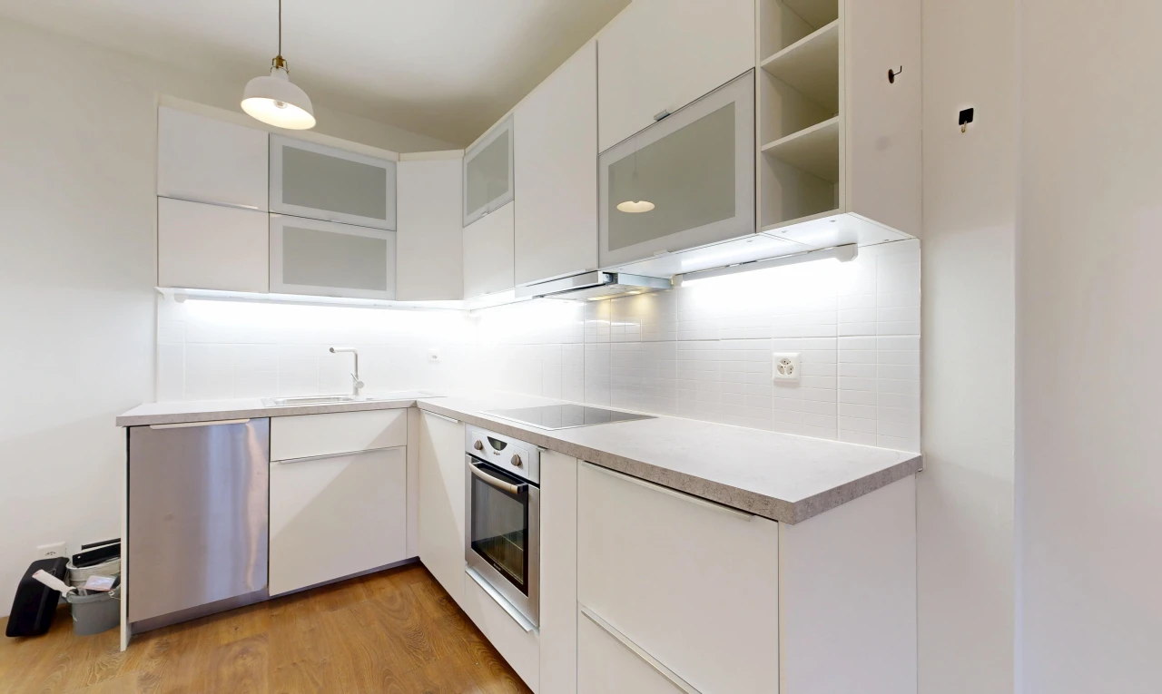 cuisine avec light countertops, four, armoires blanches, white cabinets, et éclairage suspendu