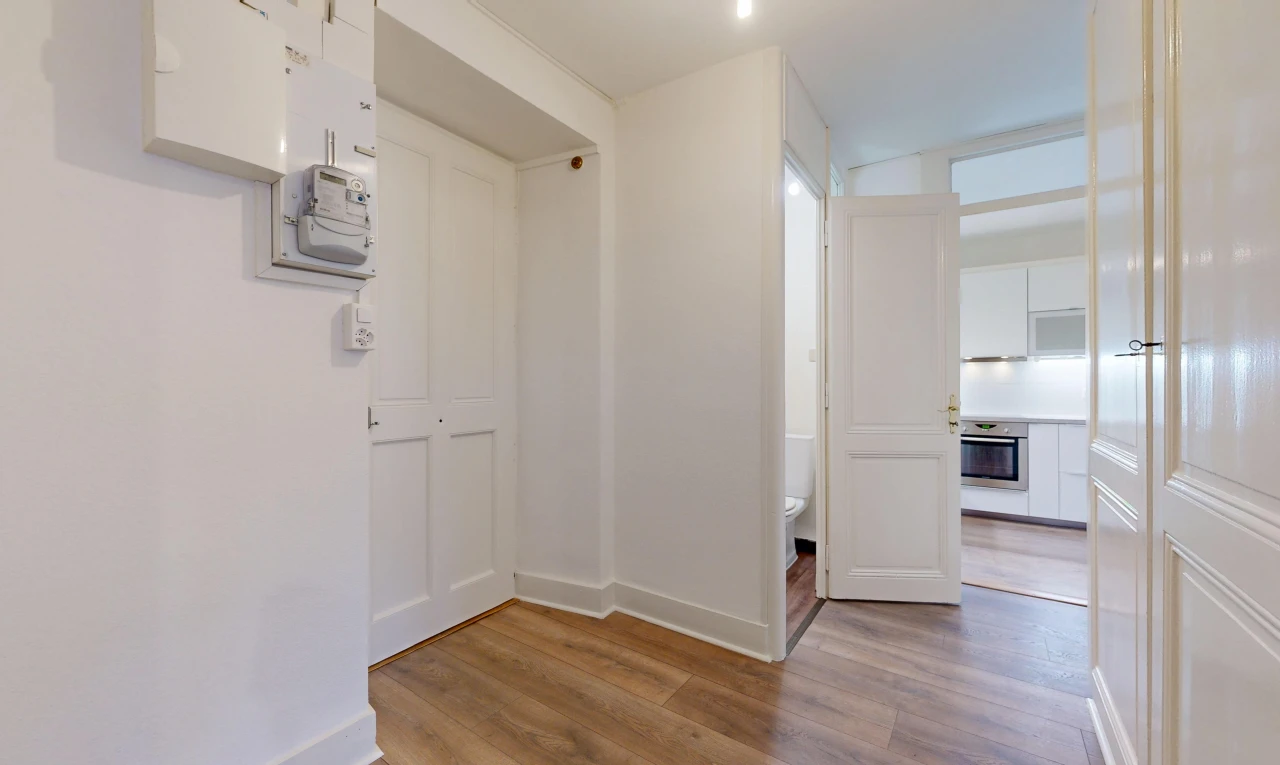 couloir avec cloison sèche, drywall, sol en finition bois, wood finish floor, et inside property