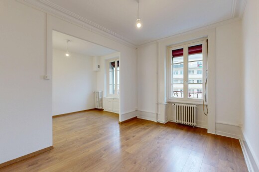 pièce vide avec éclairage suspendu, radiateur, cloison sèche, drywall, et sol en finition bois