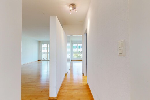 couloir avec wood finish floor, sol en finition bois, light floor, inside property, et baseboards wall
