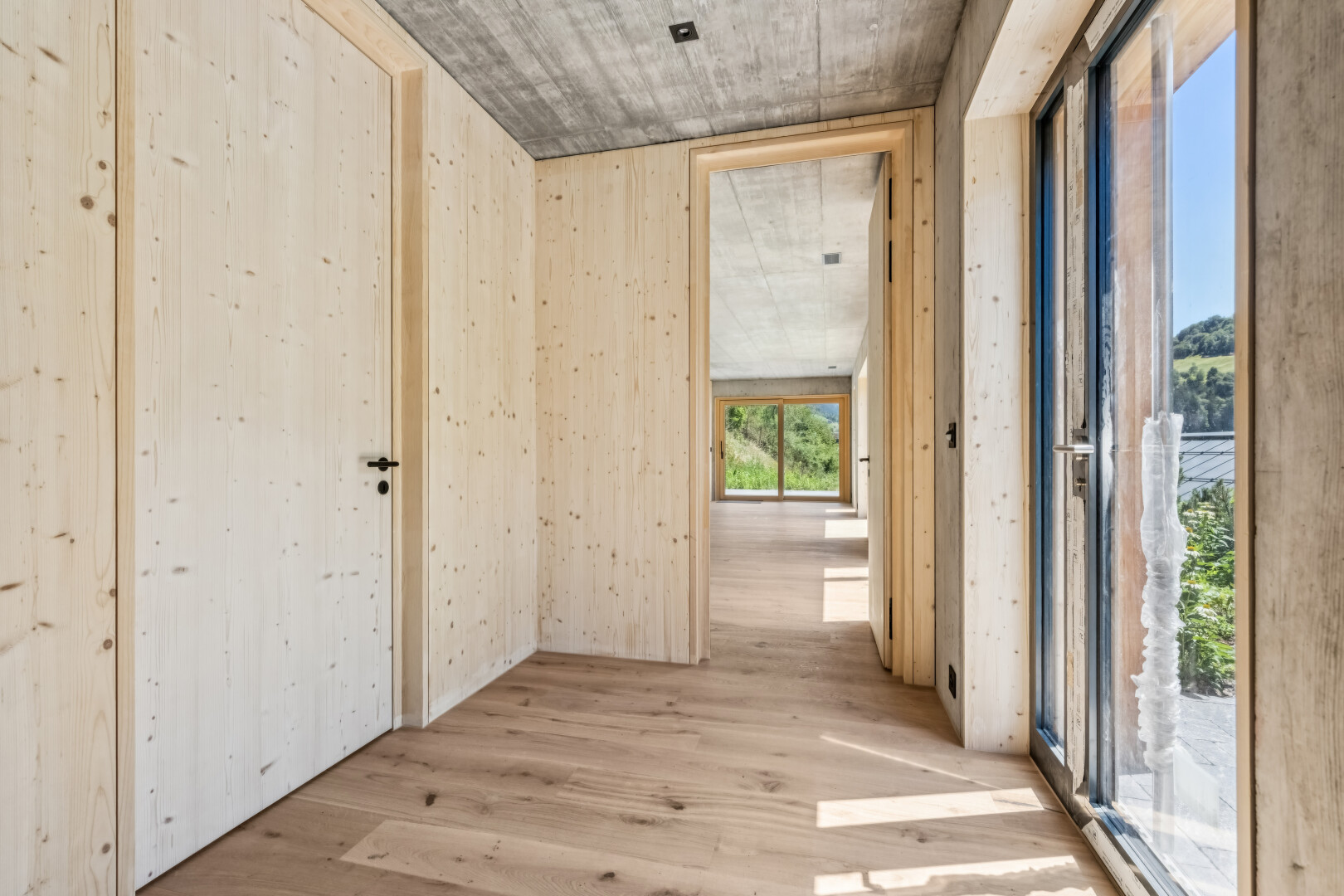 halle / korridor mit betondecke, concrete ceiling, holzfußboden, wood finish floor, und inside property