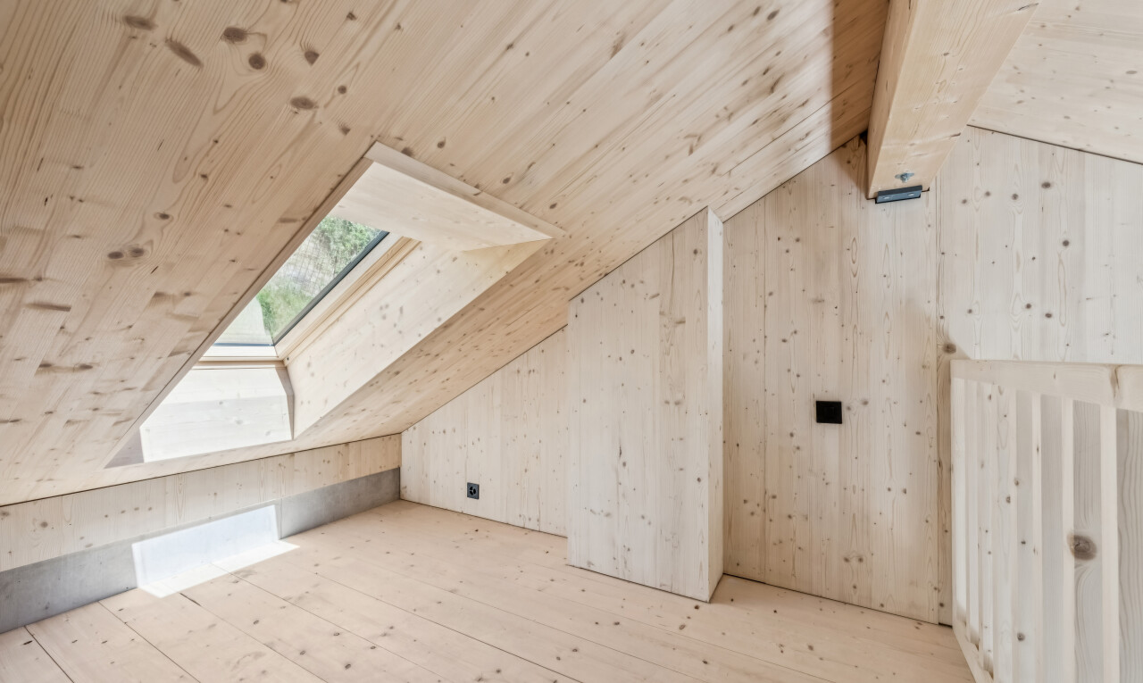 leerer raum mit dachfenster, vaulted ceiling, dachschräge, dated wood wall, und hardwood floor