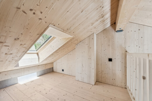 leerer raum mit dachfenster, vaulted ceiling, dachschräge, dated wood wall, und hardwood floor