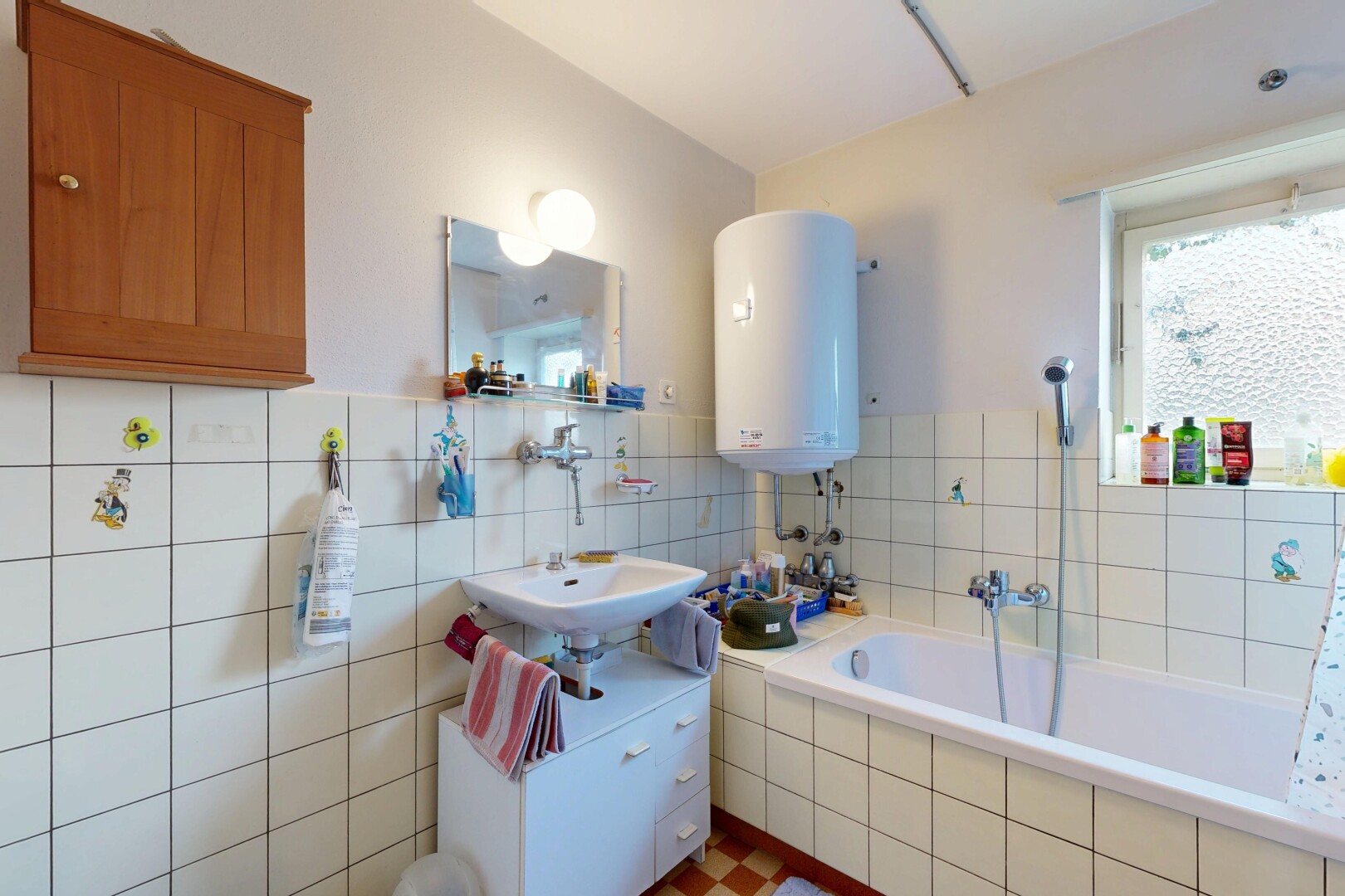 salle de bains avec miroir, chauffe-eau, salle de bain complète, inside property, et lavabo (ou coiffeuse selon le contexte)