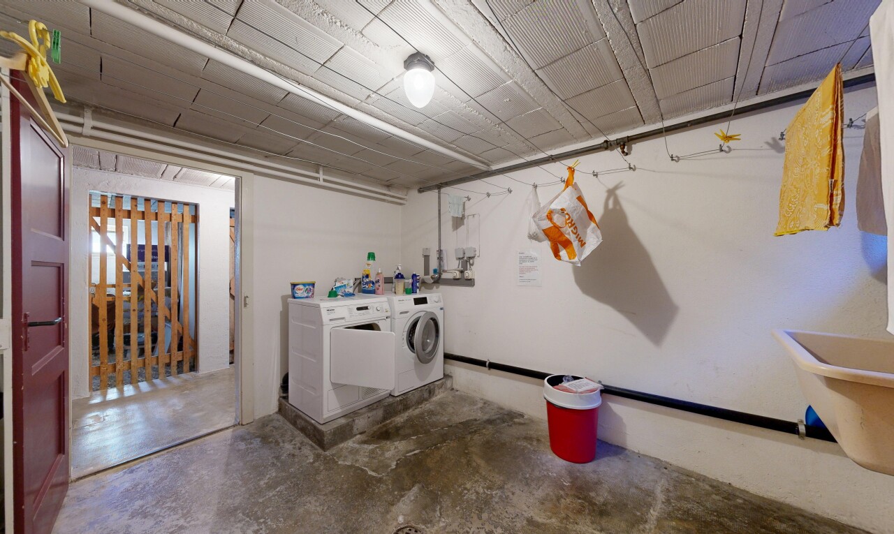 buanderie avec sol en béton, concrete floor, cloison sèche, drywall, et inside property