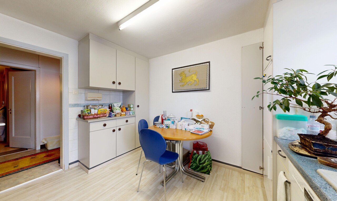 cuisine avec armoires blanches, white cabinets, light floor, sol en finition bois, et wood finish floor