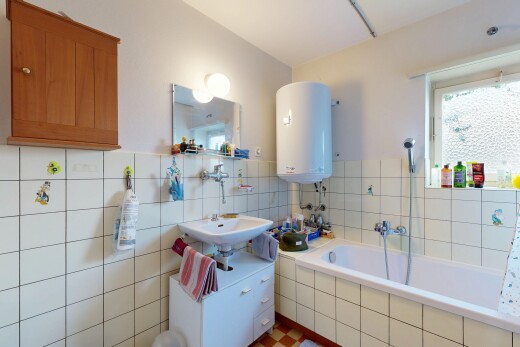 salle de bains avec miroir, chauffe-eau, salle de bain complète, inside property, et lavabo (ou coiffeuse selon le contexte)