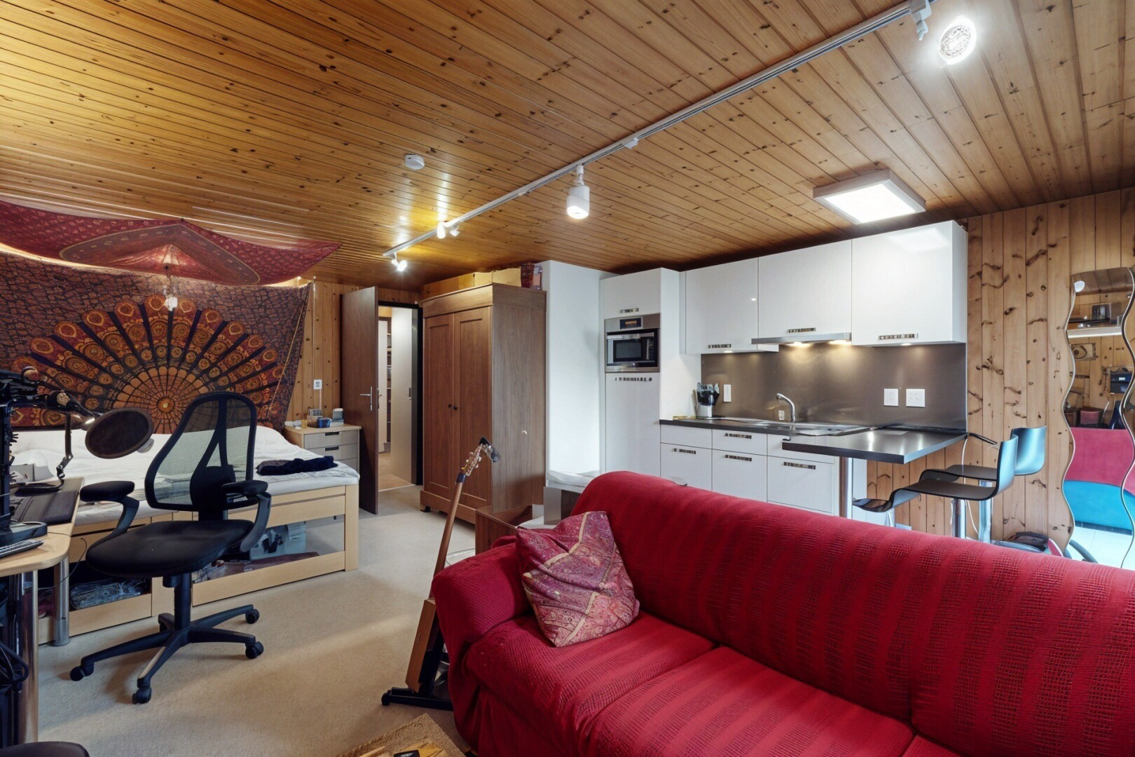 salon avec inside property, wood ceiling, plafond en bois, track lighting, et éclairage sur rail