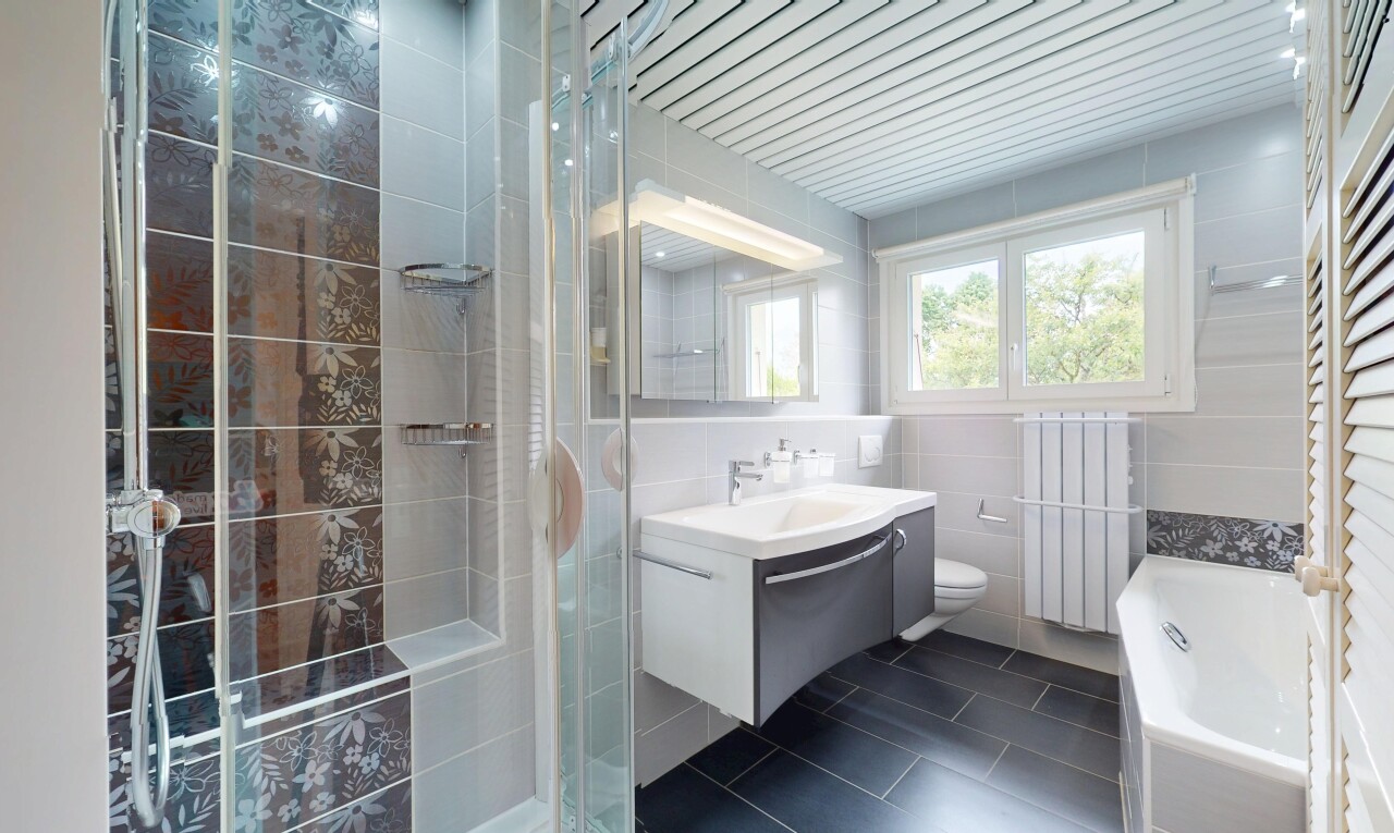 salle de bains avec tile wall, mur en carrelage, évier, lavabo (ou coiffeuse selon le contexte), et radiateur