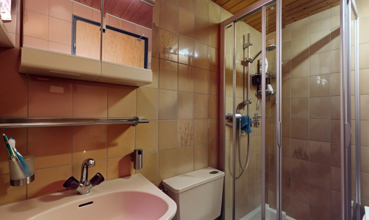 salle de bains avec tile wall, mur en carrelage, évier, toilette, et douche