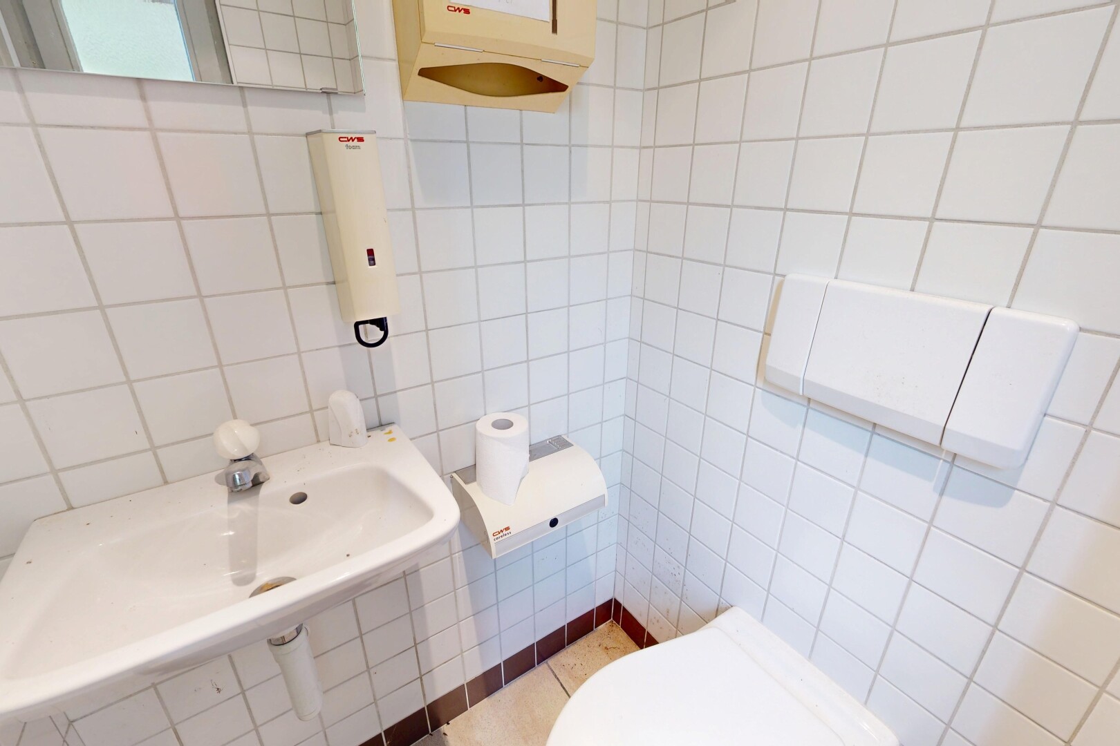 salle de bains avec toilette, tile wall, mur en carrelage, inside property, et évier